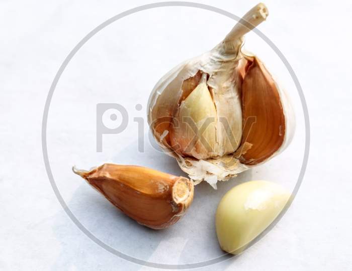 Close-Up Piece Of Dried Garlic And Garlic Bulb On A White Background.Copy Space For Text.