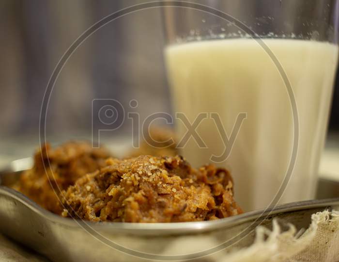 View Of Crunchy Coconut Cookies Along With Hot Milk In A Glass.