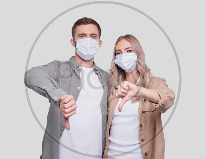 Couple Wearing Medical Mask Showing Thumb Down Isolated. Man And Woman Hugging, Lovers, Friends, Couple, Virus Concept