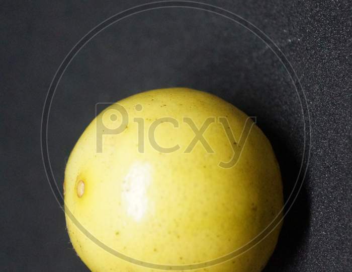 Half sliced lemon filled with black  juice, and pullpy seeds , citrus sour fruit with clear  background
