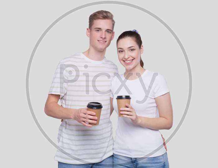Couple Holding Coffee Cups Isolated. Couple Standing And Holding Coffee To Go Cup. Man And Woman Hugging, Lovers, Friends, Couple Concept.