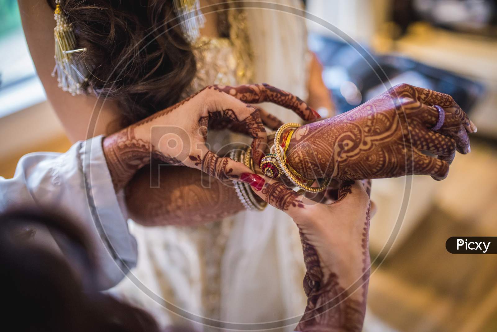 Hand Of An Indian Bride Decorated With Henna Or Mehndi Wearing Gold Bangle Made With Diamond And Red Ruby