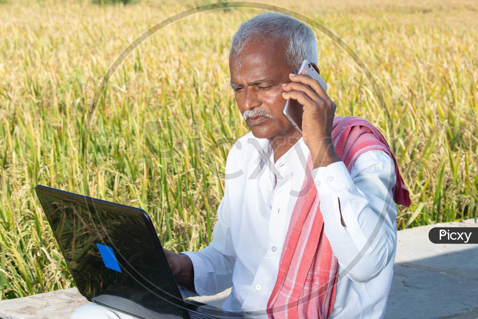 Image of Indian Farmer Talking On Mobile Phone While Busy Looking Into  Laptop Near The Agriculture Farmland - Concept Of Farmer Using Technology,  Internet In Rural India.-WS742544-Picxy