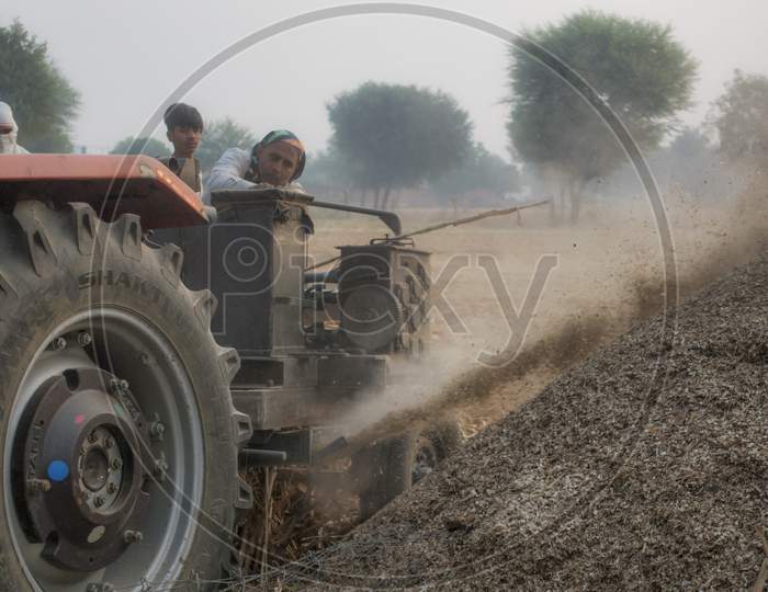 Farmer With Tractor At Work