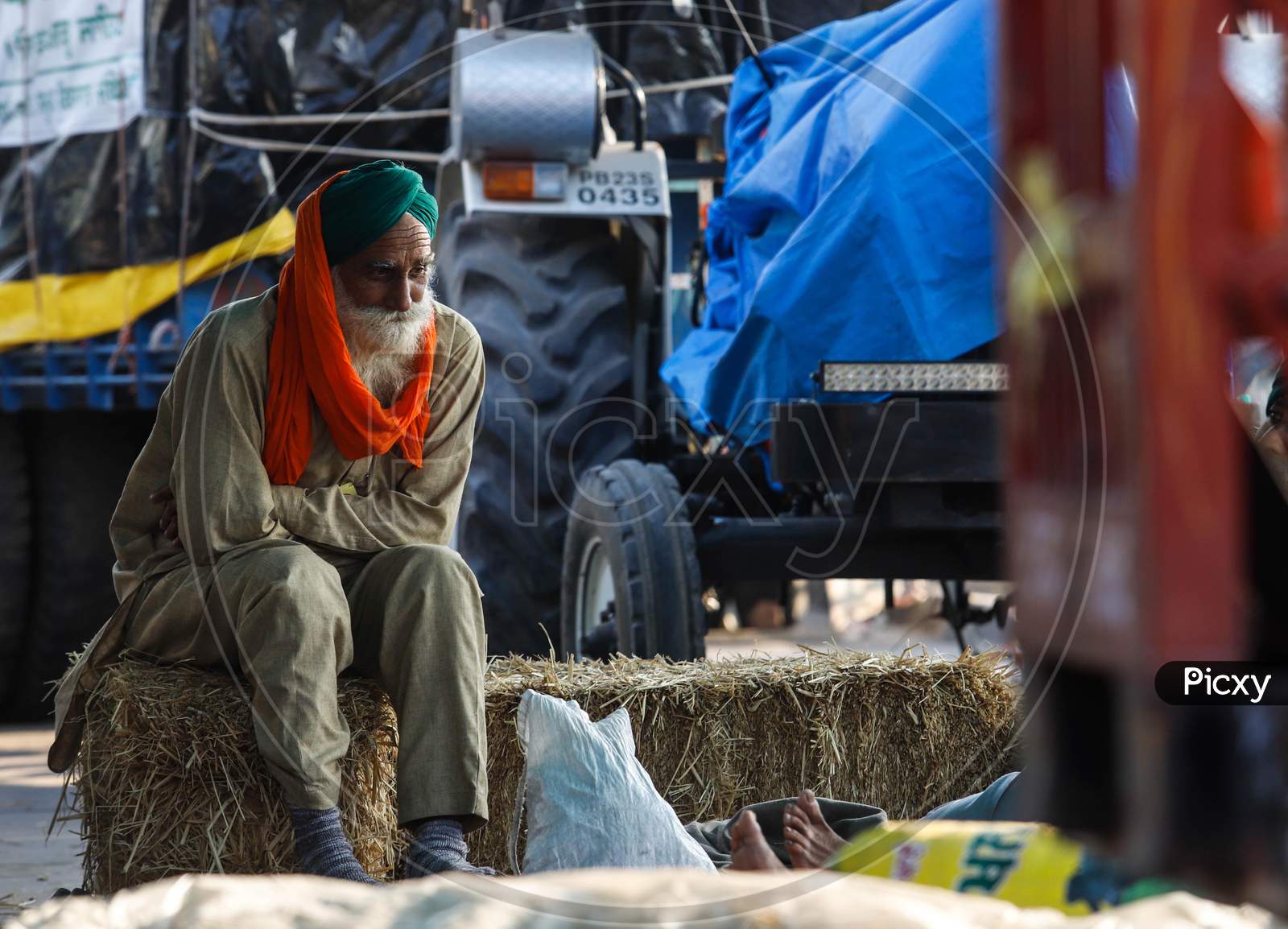 A Farmer Sits Over A Bundle Of Hay During  The Ongoing Sit-In Protest At Singhu Border Against New Farm Laws On December 13, 2020 Near New Delhi, India. Thousands Of Farmers Are Protesting On Various Borders Of The National Capital Since November 26.