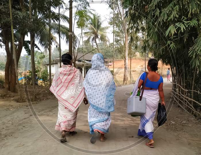 An ASHA worker walking with two other women on a village road