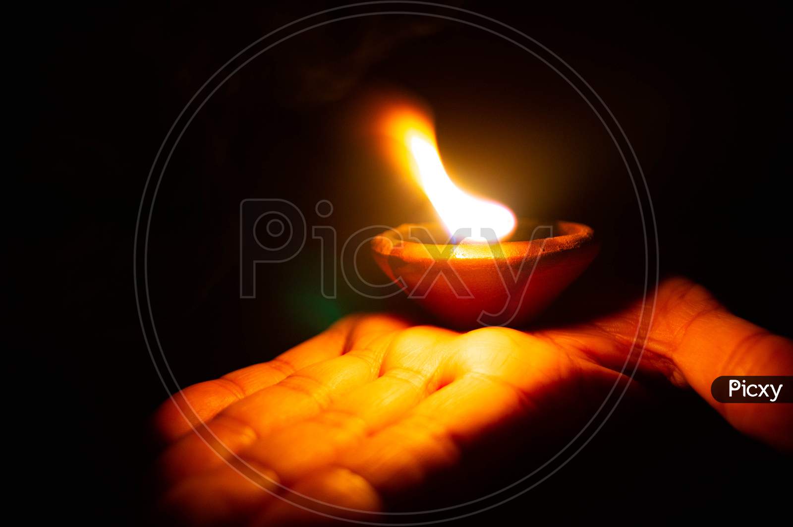 Lit Diya Or Clay Lamp On The Palm Of A Person