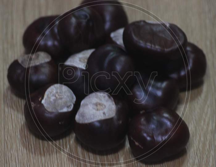 Close-Up Of Bunch Of Dried Chestnut Fruits Over Wooden Background.