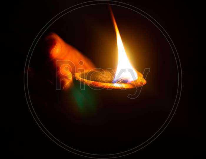 Lit Diya Or Clay Lamp On The Palm Of A Person