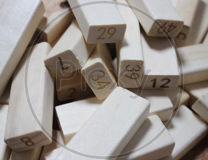 Pile Of Wooden Blocks With Engraved Letters Dispersed On Floor.