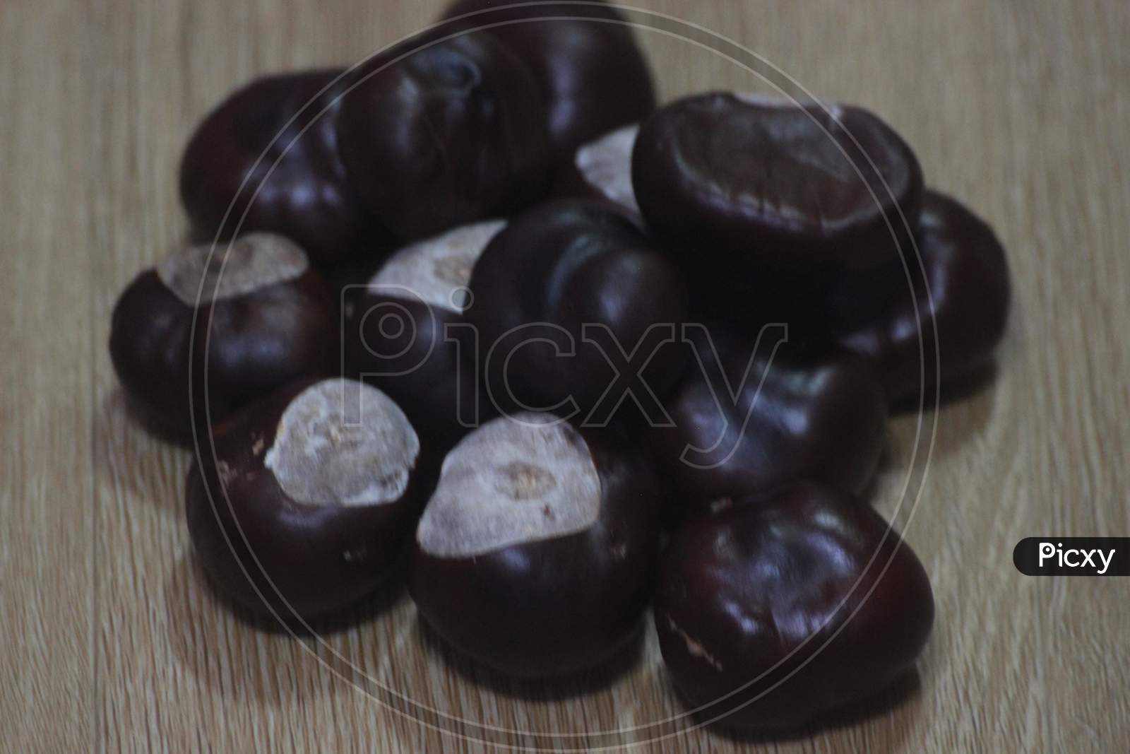 Close-Up Of Bunch Of Dried Chestnut Fruits Over Wooden Background.