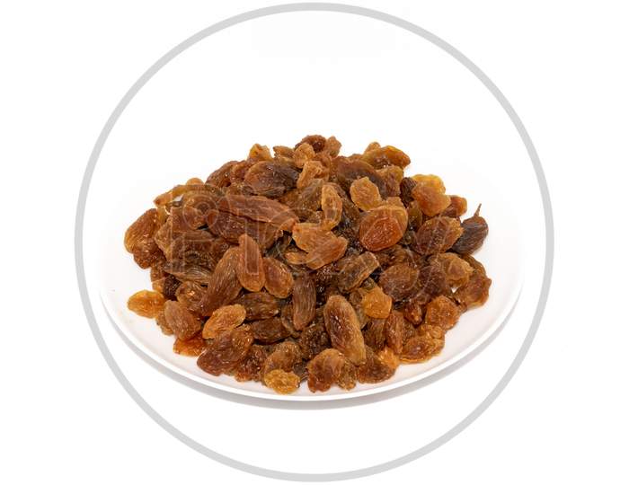 Golden raisins on plate on white background