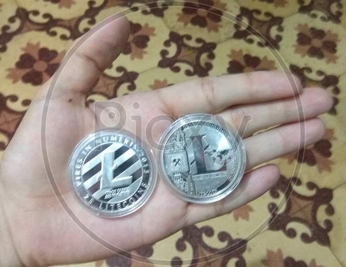 Two Silver Coated Litecoin Cryptocurrency View in Hand