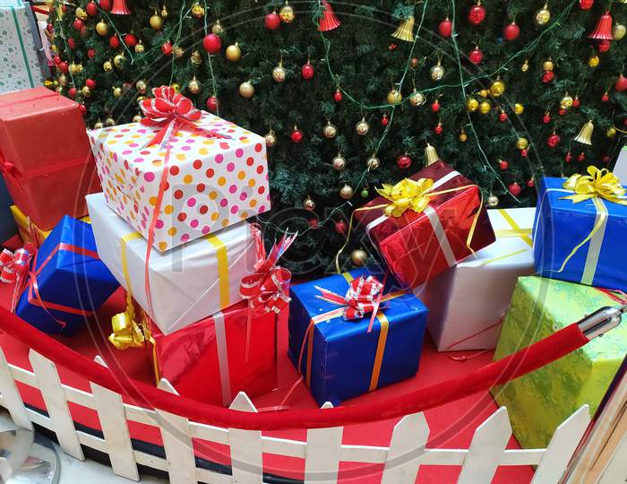 Christmas gift boxes are placed near the Christmas tree on the occasion of Christmas festival in mall of India.
