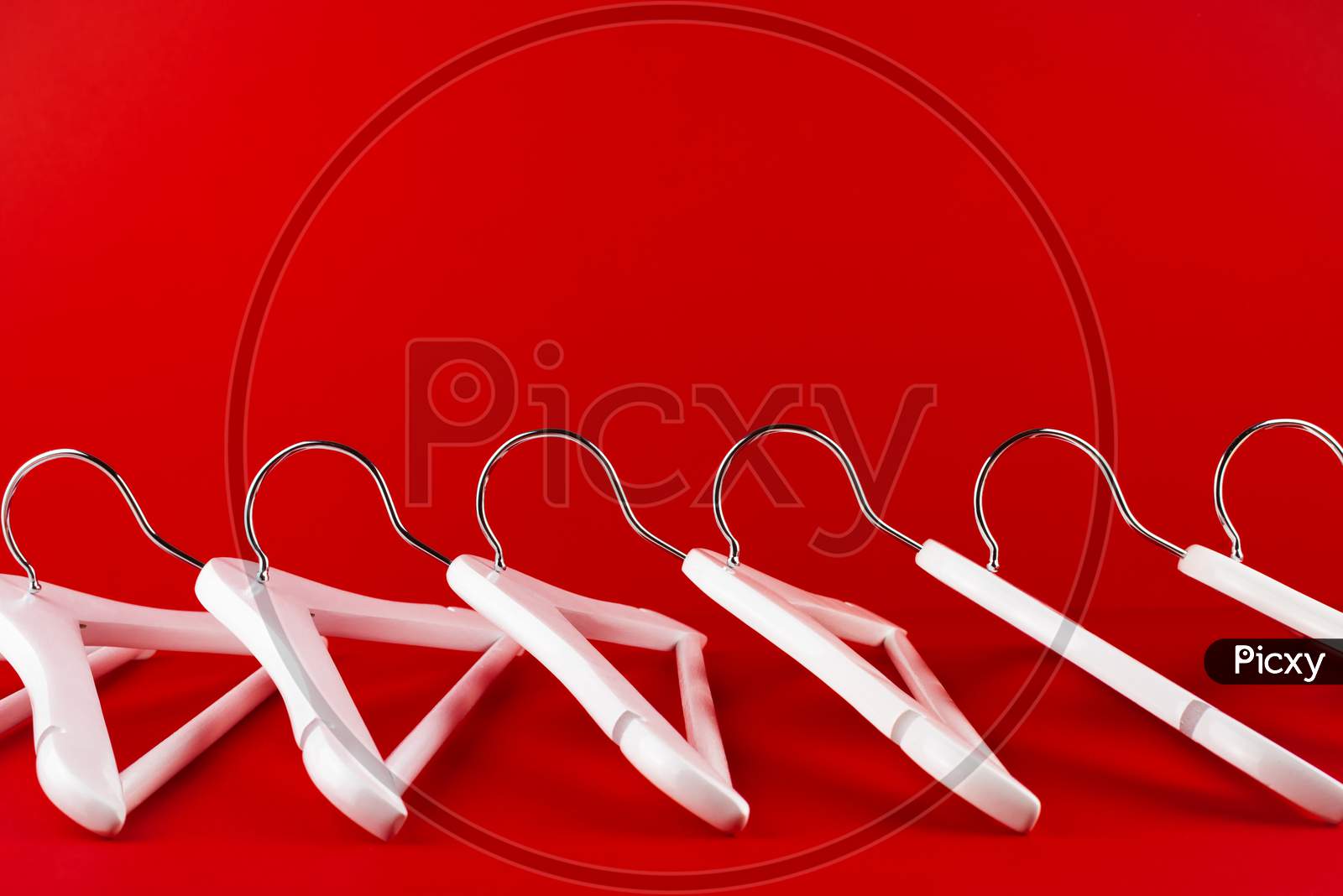 White Hangers On A Red Background. Sales Clothes Concept.