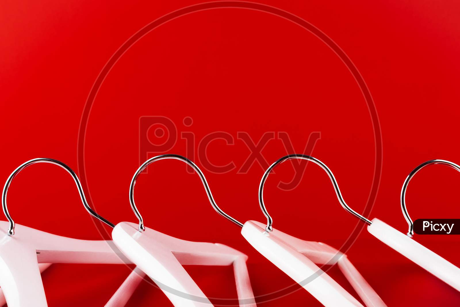 White Hangers On A Red Background. Sales Clothes Concept.