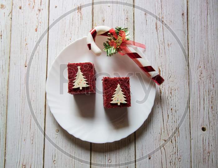 Red velvet pastries on a plate along with Christmas decorations