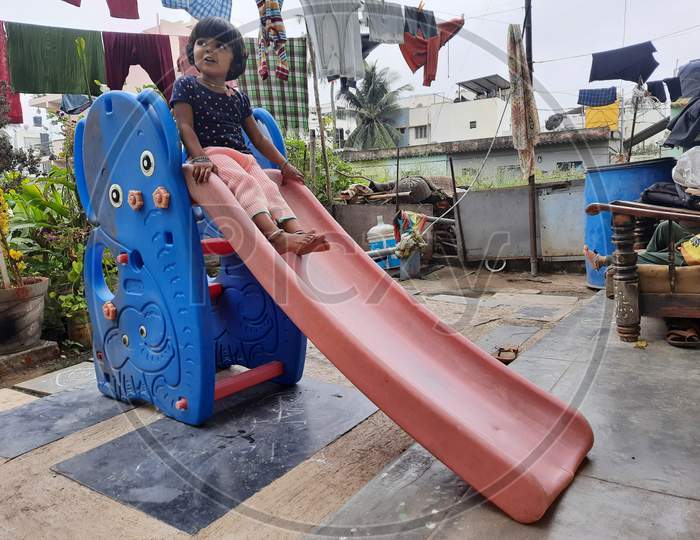Group of Indian Kids Playing in a Mobile Plastic slides, climbers in front of the house