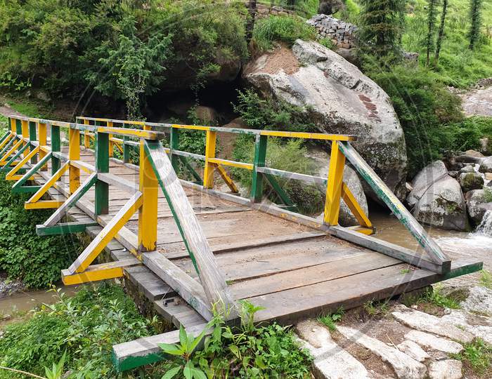 Photo of old wooden walking bridge in hilly region of Himachal Pradesh, Yellow and green colored wooden bridge in northern Indian village.