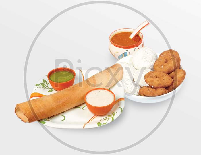 Group Of South Indian Food Like Paper Masala Dosa (Dhosa), Idli Or Idly, Wada Or Vada (Medu Vada), Sambhar, Sambar And Coconut Chutney, White Background.