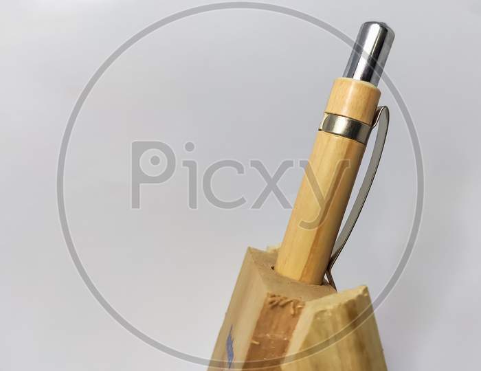 Wooden Pen With Wooden Pen Stand In A White Isolated Background