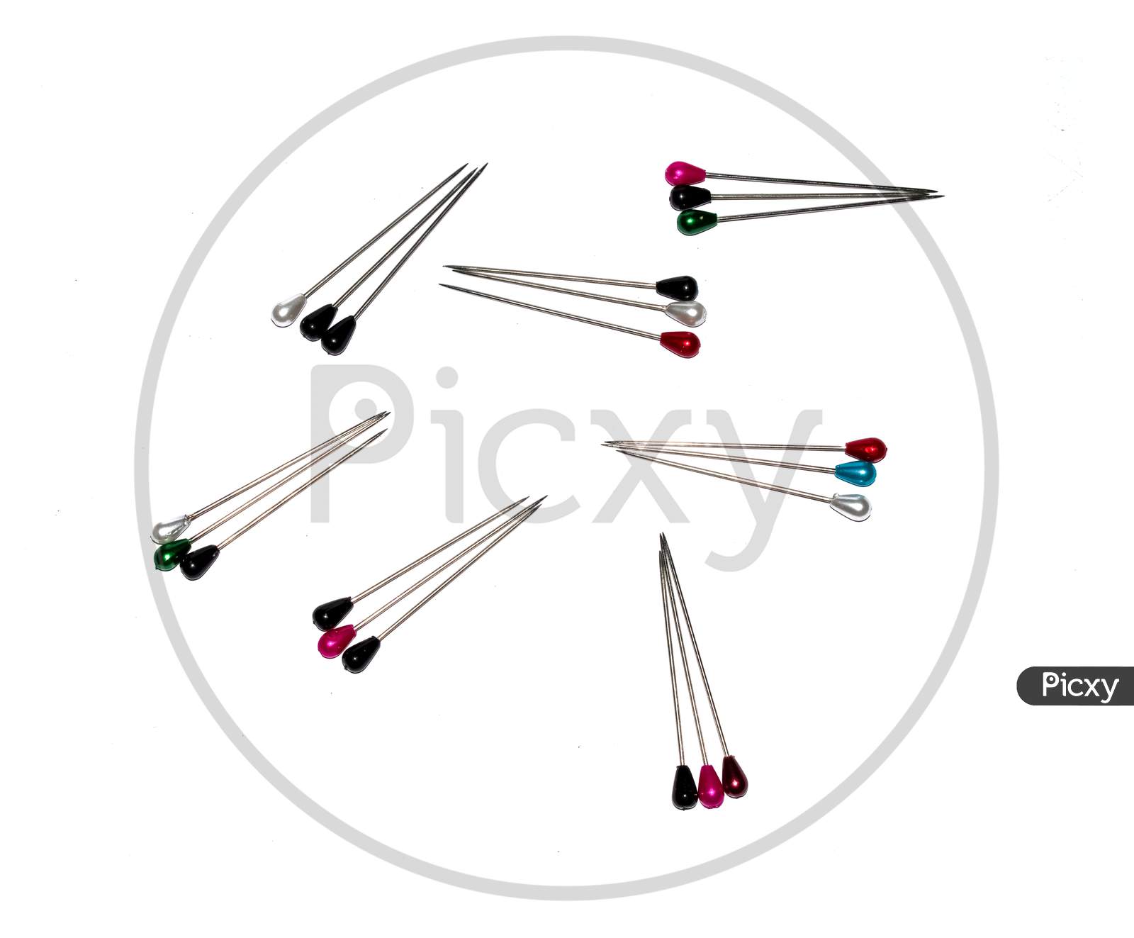 Arrangement of multiple colour pearl head pins having shallow depth of field isolated on white.