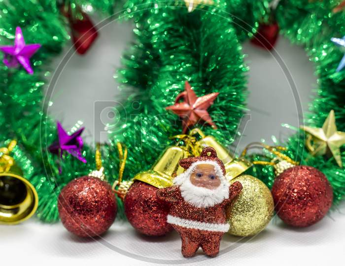 Close-Up Shot Of Santa Claus Wearing A Christmas Garland Adorned With Ornaments