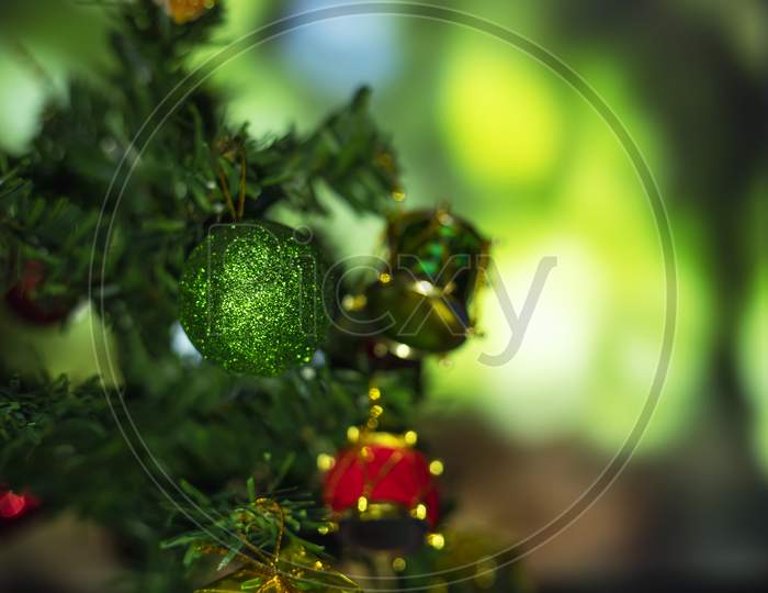 Close Up Of Balls On Christmas Tree. Bokeh Garlands In The Background. New Year Concept.