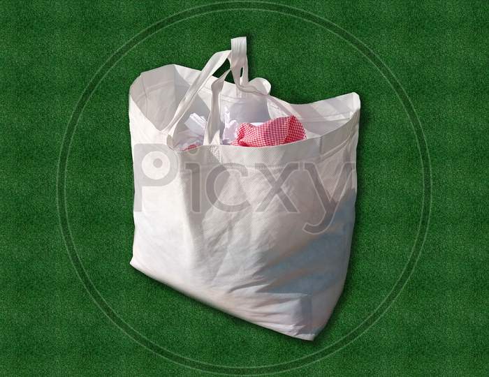 Say no to plastic bags. Unpainted ECO White Bag Isolated on green grass background. Mockup of blank white Bag. Non Woven Fabric Shopping & Gift Bag. Environment Save with Clean and Green.
