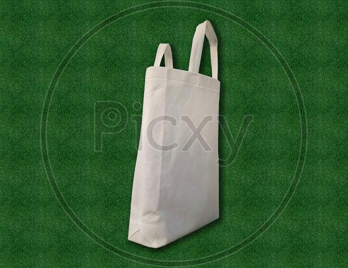 Say no to plastic bags. Unpainted ECO White Bag Isolated on green grass background. Mockup of blank white Bag. Non Woven Fabric Shopping & Gift Bag. Environment Save with Clean and Green.
