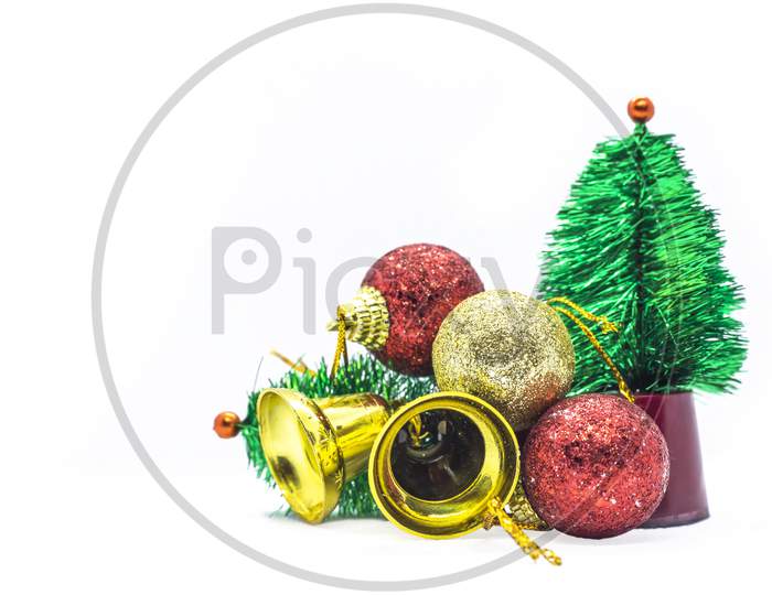 Miniatures: Small Christmas Tree, Golden Bells And Balls On White Background.