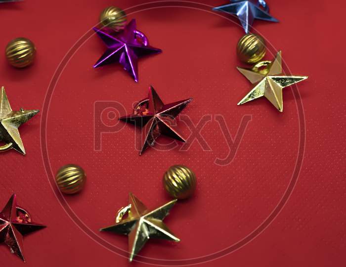 Christmas Composition. Colorful Stars And Balls On A Red Background. Flat Lay, Top View, Copy Space