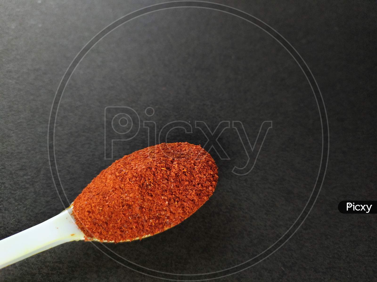 Red chili powder on black background.