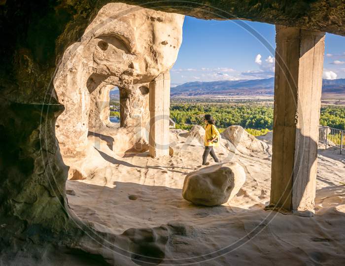 Female Tourist Walks Around Uplistsikhe Cave City Exploring Architectural Structures