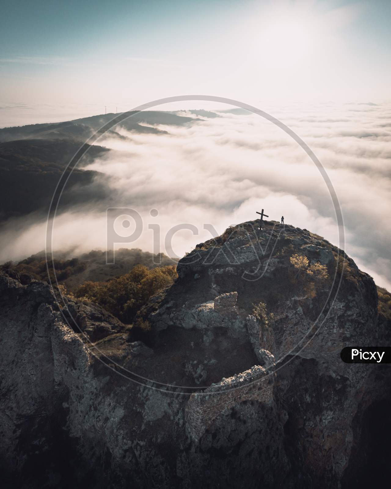 Dramatic Aerial View Of Kojori Fortressabove The Clouds With Person Sillhouette And Cross On Top