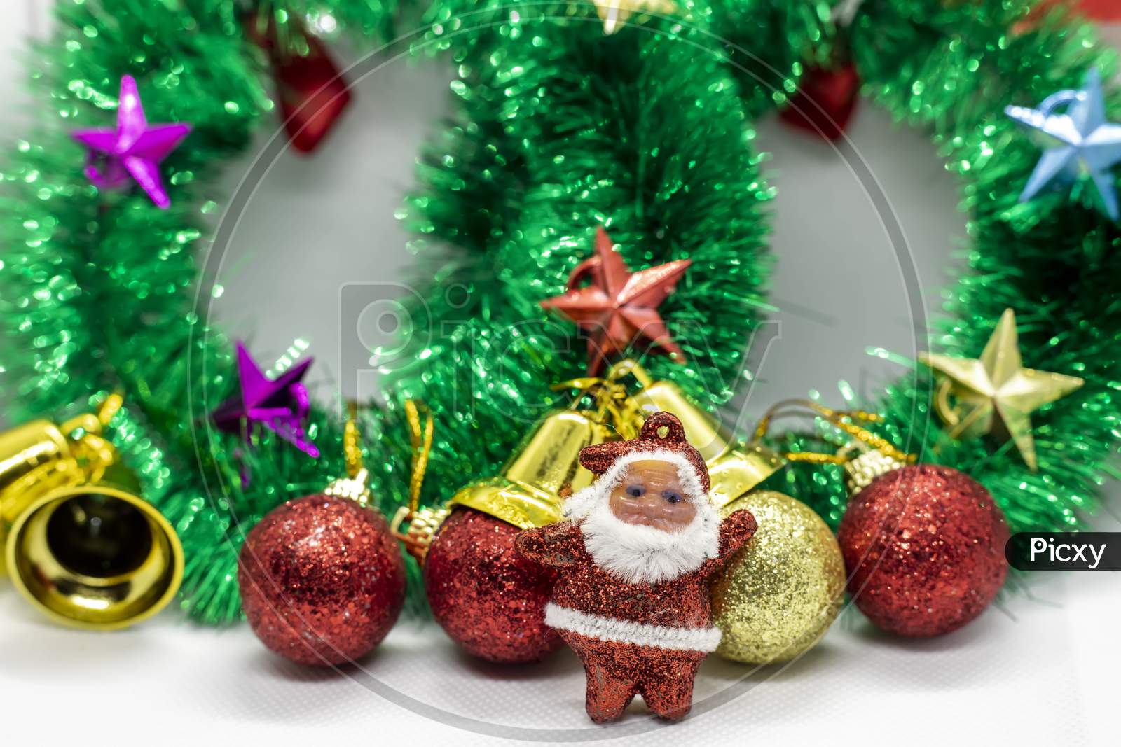 Close-Up Shot Of Santa Claus Wearing A Christmas Garland Adorned With Ornaments