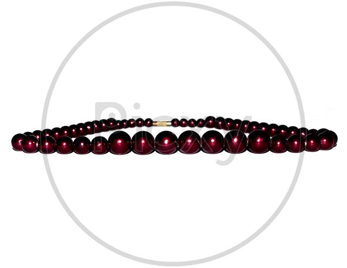 Reddish brown pearl strand necklace stone arrengement having shallow depth of field isolated on white.