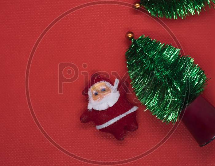 Top View Christmas Tree With Santa Claus On Red Studio Background. Copy Space
