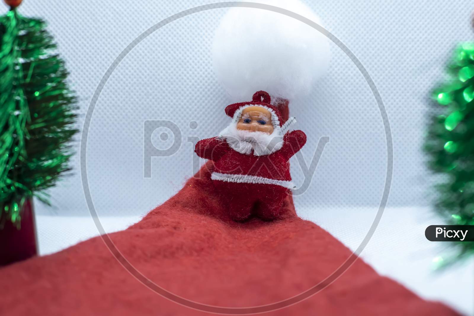 Santa Claus Stands In A Santa Claus Hat Near A Tree On A White Background