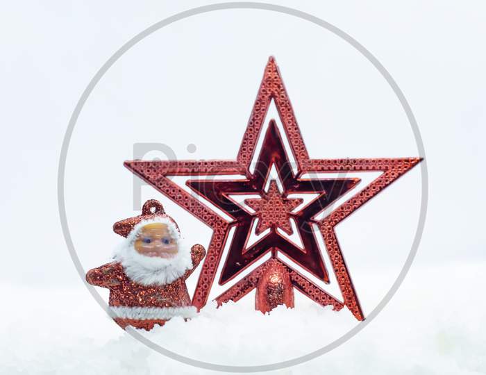 Merry Christmas And Happy New Year Greeting Card. Miniature Santa Claus Standing With The Star On The Winter Christmas Landscape.