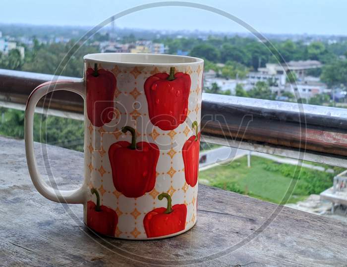 A Beautiful White And Red Textured Mug On A Table With Natural Background Countryside Of Bangladesh