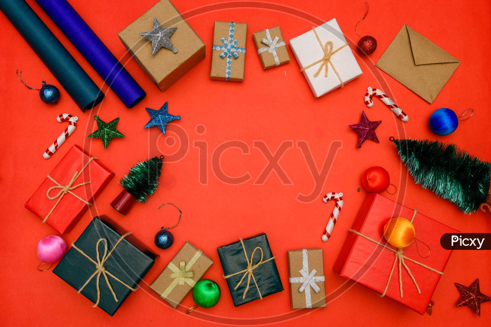 Christmas background with gift boxes, clews of rope, paper's rools and decorations on red. Preparation for holidays. Top view with copy space.