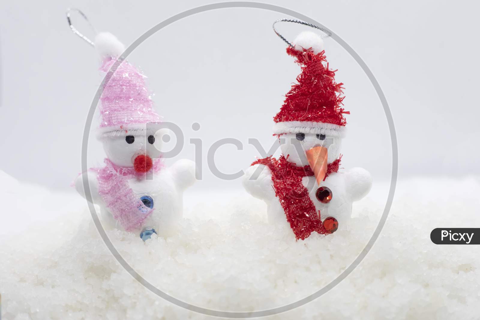 Snowmen Standing In Winter Christmas Landscape. New Year Concept. Winter Scene With Snow Man On White Snow Background