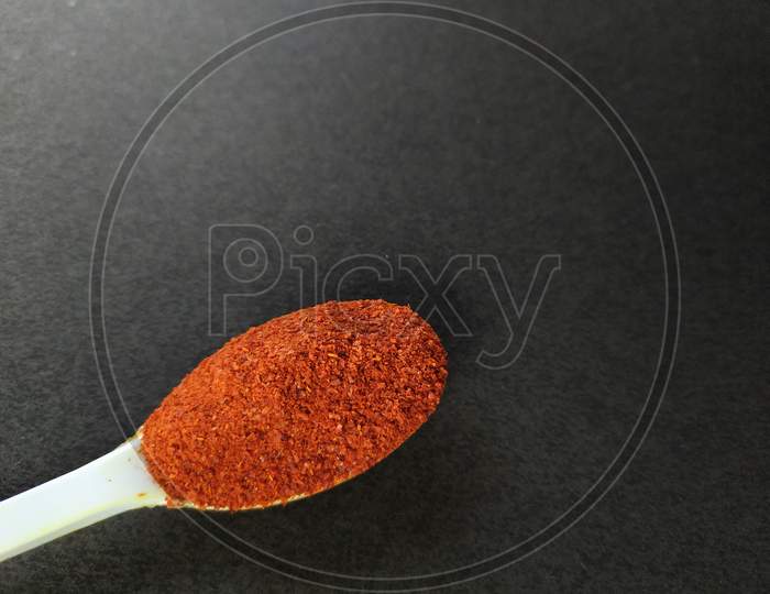 Red chili powder on black background.