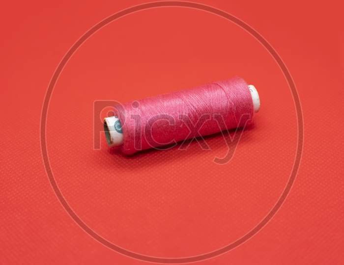 Bobbin Of The Thread On A Red Background
