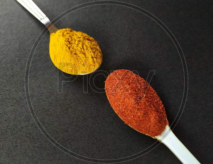 Cooking spices, turmeric and red chilli powder on black background.