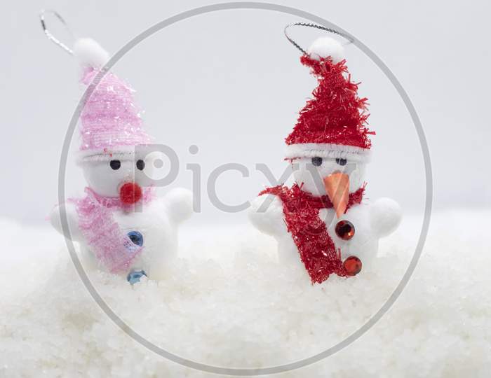 Snowmen Standing In Winter Christmas Landscape. New Year Concept. Winter Scene With Snow Man On White Snow Background