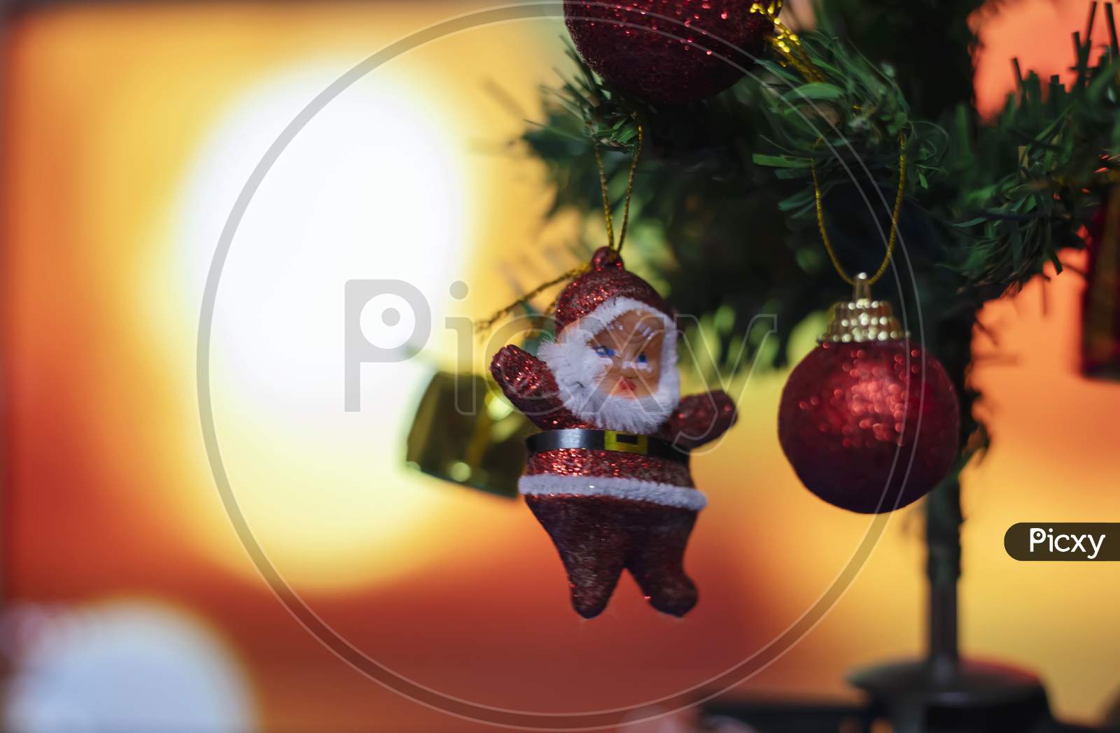 Merry Christmas And Happy New Year Concept, Closeup Of Sanda Clause Hanging From A Decorated Tree With Bokeh, Xmas Holiday Background.
