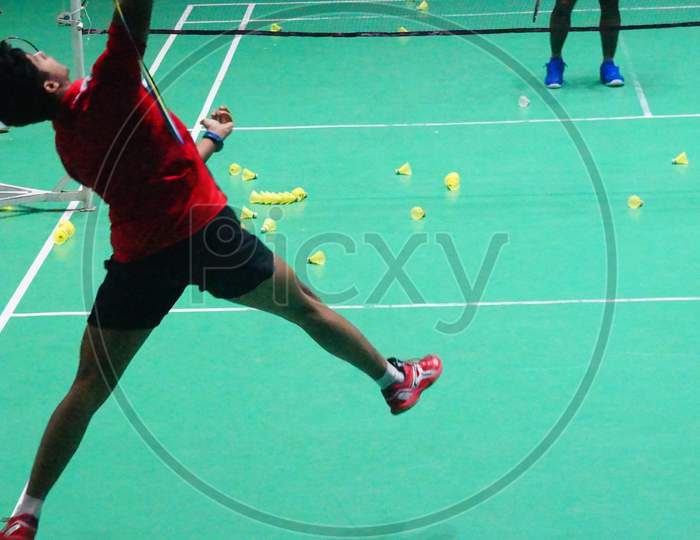 Image of Badminton Player attempting Over head straight strokes