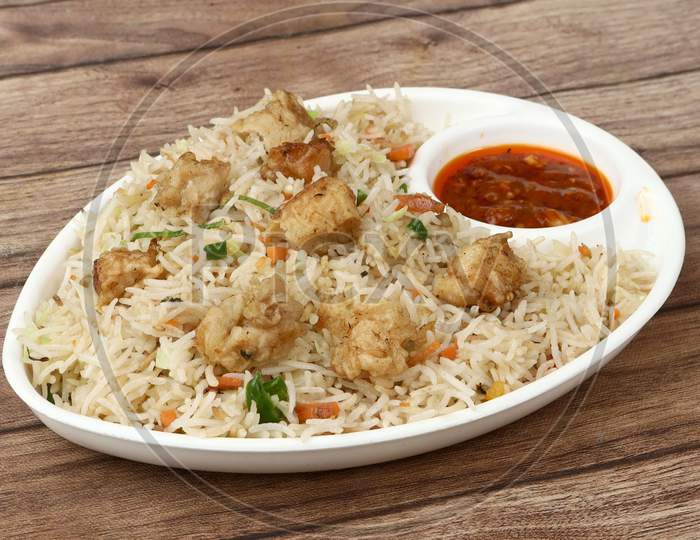 Indian Cuisine Healthy And Tasty Chicken Fried Rice With Tomato Sauce Served In White Bowl Over A Rustic Wooden Background, Selective Focus